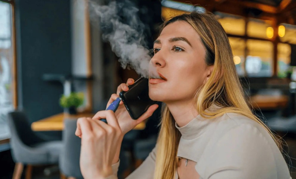woman vaporising e-cigarette