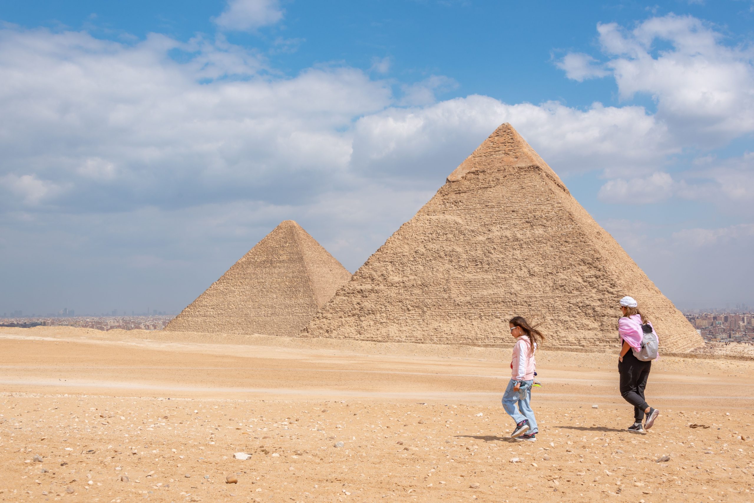 Travelers walk near the Pyramids of Giza, showing visitors can experience Egypt beyond the ancient monuments.